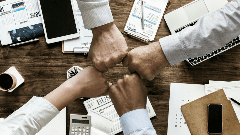A team fist bumps affirming their succession planning culture.